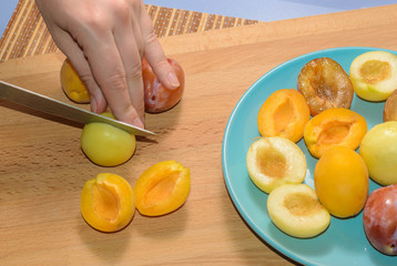 Hand cuts fruit on a wooden board