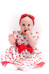 Little girl in white with a red dress with a bow on her head