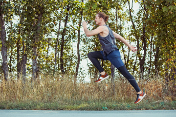 Running sport. Man runner sprinting outdoor in scenic nature. Fit muscular male athlete training trail running for marathon run.