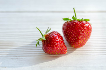two strawberries on a wooden table