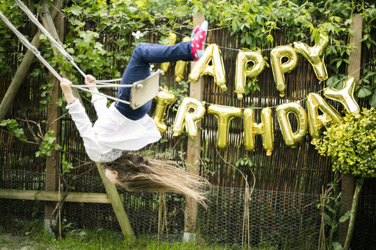 Girl swinging head first in the garden