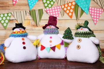 Three soft handmade toy snowman dolls. New Year's decor, symbol. New Year celebration
