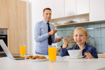 Pleasant young girl enjoying her breakfast