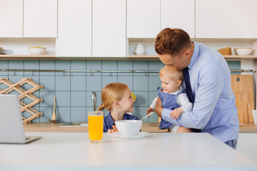 Nice happy man holding his younger daughter