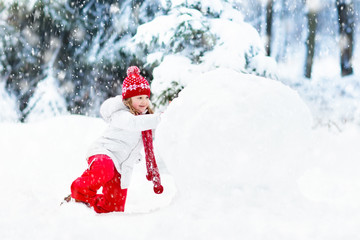 Kids building snowman. Children in snow. Winter fun.