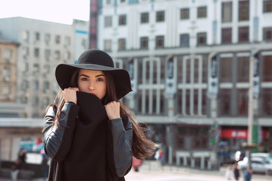 Outdoor closeup shot of woman in fashionable black coat and stylish hat.Female fashion concept