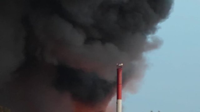 Helicopter is putting out a fire in the city. Extinguishing fire with water from the air. helicopter flames and smoke. A team of fire fighters hold. hose and put out a house fire. firemen fire