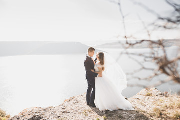 Happy and romantic scene of just married young wedding couple posing on beautiful beach