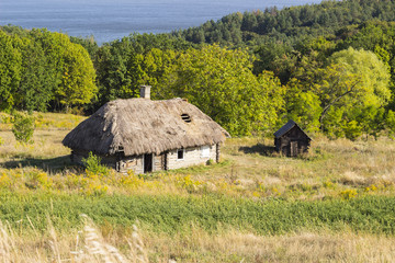 Fototapeta na wymiar old wood house with thatched roof in summer Sunny day, ancient building