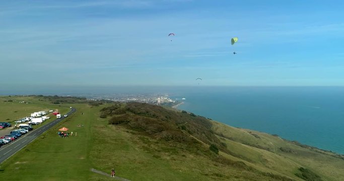 Aerial view of para gliders at Beachy Head, Southern England, with the sea and the town of Eastbourne