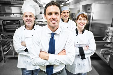 Fototapeta na wymiar Restaurant manager posing in front of team of chefs