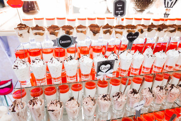 Delicious and tasty dessert table with cupcakes shots at reception closeup