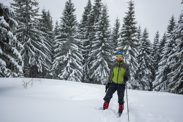 Fototapeta na wymiar Traveler man, in a goggles, stands in a deep snow