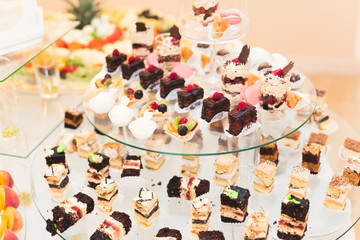 Delicious sweets on wedding candy buffet with desserts, cupcakes