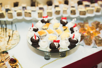 Delicious and tasty dessert table with cupcakes shots at reception closeup