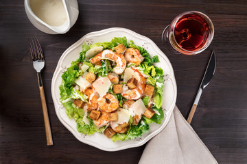 Shrimp Caesar salad with sauce and wine