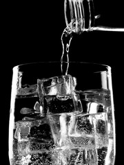 Bottle of soda mineral water pouring into glass