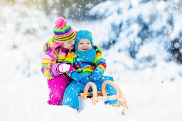 Fototapeta na wymiar Kids on sleigh ride. Children sledding. Winter snow fun.