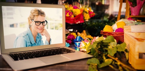 Composite image of laptop on table with leaves and ribbons