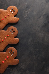 Homemade gingerbread cookies for Halloween in the form of gingerbread men vampire on dark concrete background with copy space. Top view