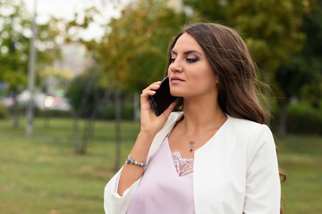 Arrogant businesswoman talking on mobile phone with the clients, partners, or suppliers. Female boss expresses grievances to the secretary or employees. 