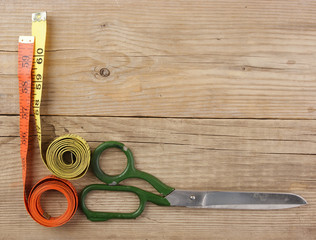sartorial meter and scissors on the old wooden background