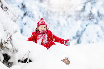 Fototapeta na wymiar Child playing with snow in winter.Boy in snowy park.