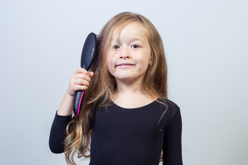 Little girl combing her hair