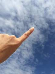female hand touching or pointing to something on blue sky
