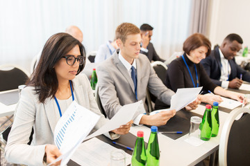 Obraz premium businesspeople with papers at conference