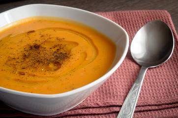 Pumpkin soup on brown background