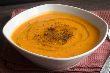 Pumpkin soup on brown background