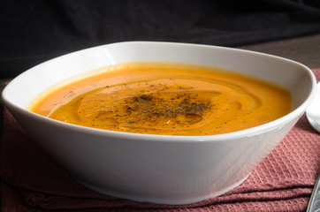 Pumpkin soup on brown background