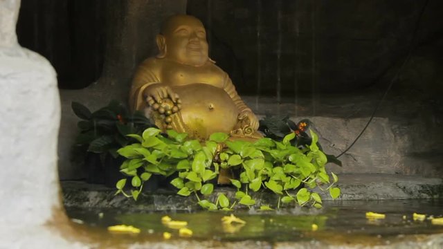 Golden Buddha statue in little pond with water stream. Golden mount (Wat Saket) Bangkok Thailand.
