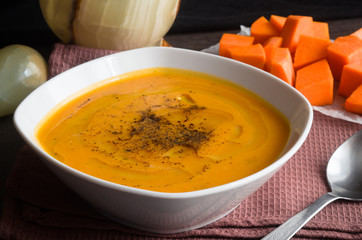 Pumpkin soup on brown background