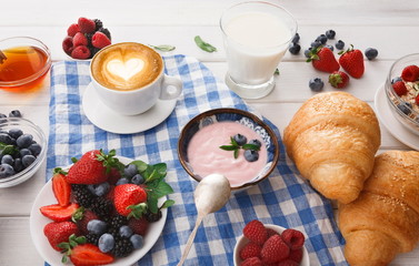 Continental breakfast with croissants and berries on checkered cloth