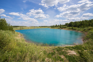 Fototapeta na wymiar Abandoned flooded open pit quarry mine ore with blue water