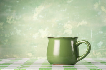 A green cup on the kitchen table