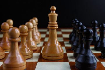 Chess game with figures on a wooden brown field, the concept of a tournament, a sport with a copy space and a selective focus