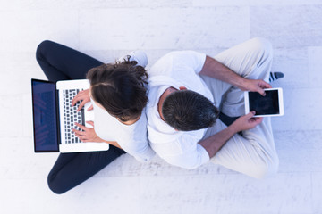 couple using tablet and laptop computers top view