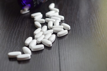 large white oval tablet on black wooden background