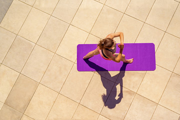 Young woman in yoga position in sunny day, outdoor, view from above.