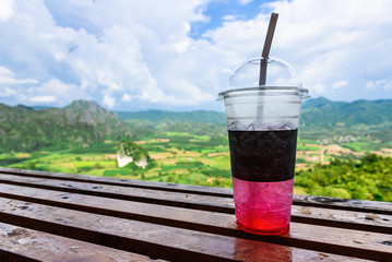 The sweet cooled red drink with ice on Natural background.