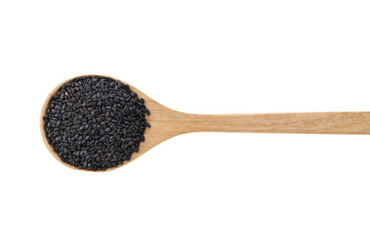 Black sesame on wood spoon isolated on white background