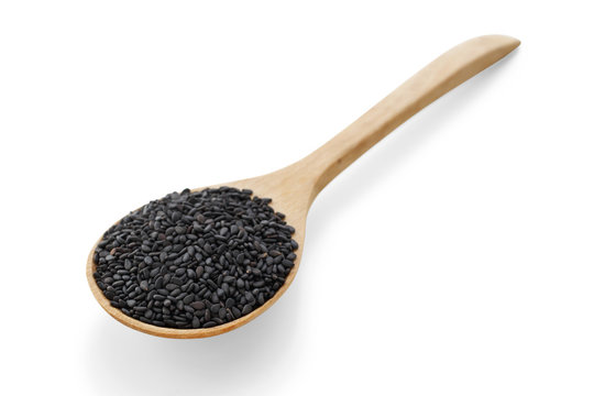 Black sesame on wood spoon on white background