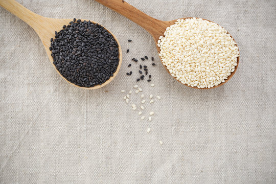 Black and white sesame on wood spoon background with space