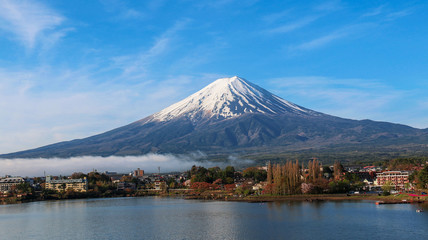 Mountain Fuji and Kawaguchiko lake with morning mist and blue sky background in Autumn season in  Japan.