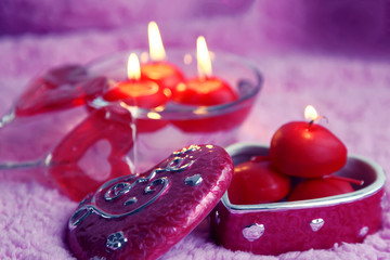 Porcelain box, lolipops and candles in the form of hearts on a pink background. Romantic concept of Valentines Day. Tinted photo