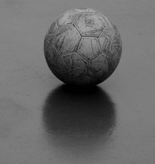 old and damaged ball at futsal court - monochrome