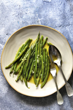 Sauteed green beans with olive oil and garlic on a serving plateTop view